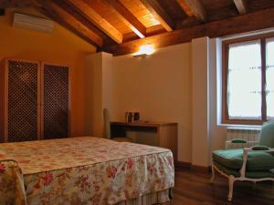 een slaapkamer met een bed, een stoel en een raam bij La cueva in Elciego