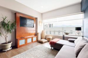 a living room with a couch and a tv at Parque Sur Beautiful apartment 2 BE - 2 BA - 2 Parkings in Mexico City