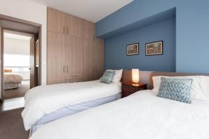 a bedroom with two beds and a blue wall at Parque Sur Beautiful apartment 2 BE - 2 BA - 2 Parkings in Mexico City