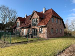a large brick house with a red roof at Pfahlbau, Ferienwohnung für 4 Personen - Erwachsene oder Kinder - in DE FEERJENHUSEN am Haubarg von Vollerwiek, Fertigstellung April 2020 in Vollerwiek