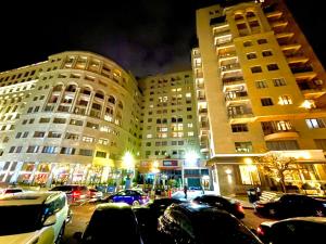a parking lot with cars parked in front of tall buildings at Armenak Apartment 5-комнатная in Yerevan