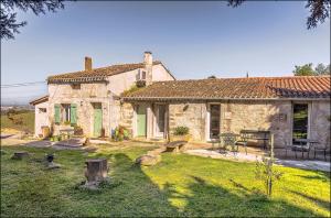 a stone house with a picnic table and a yard at Ecuries Sainte Croix in Carcassonne