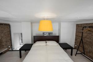 a bedroom with a large bed with a orange light at Stylish Studio Apartment in the Heart of Riga in Riga