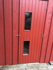 Deux fenêtres dans la porte d'une grange rouge dans l'établissement Marstrand, à Marstrand