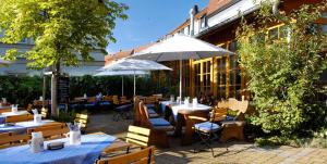 un ristorante con tavoli e ombrelloni di fronte a un edificio di Gasthaus Sindel-Buckel a Feuchtwangen