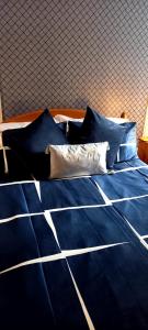ein Bett mit blauer Bettwäsche und Kissen darauf in der Unterkunft Shananagens Guesthouse in Blackpool