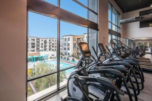 a row of exercise bikes in a gym with a large window at Luxury Condos at Anton Menlo w Pool & Amenities in Menlo Park