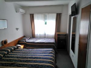 a hotel room with two beds and a window at Brisas del Este in Punta del Este