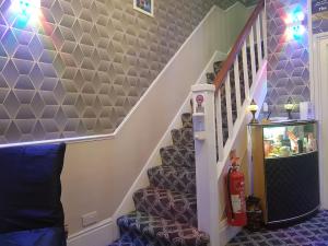 a room with a staircase with purple walls at A&P at The Sheron House in Blackpool