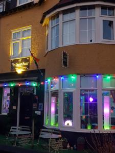 a restaurant with colorful lights in front of a building at A&P at The Sheron House in Blackpool