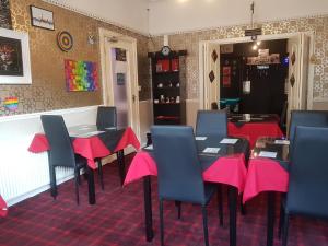 a dining room with tables and chairs with pink napkins at A&P at The Sheron House in Blackpool +69 photos