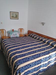 uma cama num quarto com duas cadeiras e uma mesa em Brisas del Este em Punta del Este