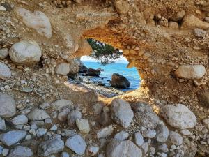 a view of the ocean through a rock cave at Apartment Dora in Makarska