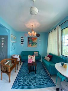 a living room with a blue couch and a table at Suhana HomeStay Semporna - Cozy Home in Semporna