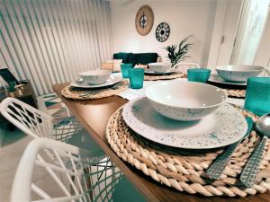 a table with plates and bowls on top of it at Beachfront Apartment Nazaré in Nazaré