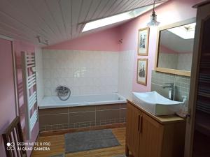 a bathroom with a tub and a sink at terre et mer in Sainte-Ramée