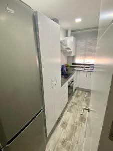 コニル・デ・ラ・フロンテーラにあるConil Apartmentのキッチン(白いキャビネット、冷蔵庫付)