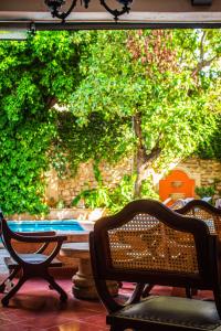 eine Terrasse mit 2 Stühlen, einem Tisch und Bäumen in der Unterkunft Casa del Balam Merida in Mérida