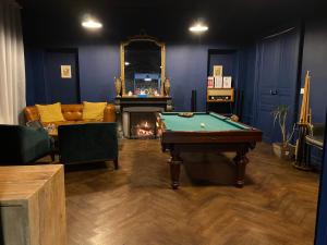 a living room with a pool table and a fireplace at LE CHARME DE ST PIERRE in Saint-Pierre-le-Moûtier