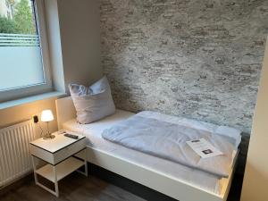 a small room with a bed and a window at City Pension Stadtlohn in Stadtlohn