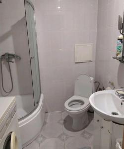 een witte badkamer met een toilet en een wastafel bij Затишна 2 кімнатна квартира Трускавець in Truskavets