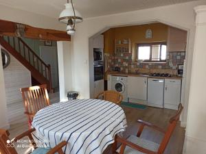 a kitchen with a table and chairs in a room at terre et mer in Sainte-Ramée +8 photos