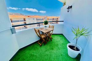 un balcone con tavolo, sedie e prato verde di Vacation Home Studio Los Cristianos ad Arona