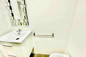 bagno bianco con lavandino e servizi igienici di Vacation Home Studio Los Cristianos ad Arona