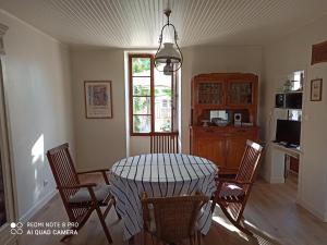een keuken met een tafel en stoelen in een kamer bij terre et mer in Sainte-Ramée