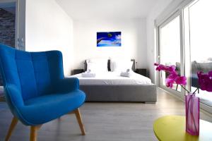 Dubrovnik Icy Guest House في دوبروفنيك: غرفة نوم بسرير وكرسي ازرق