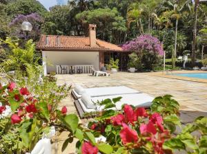 un patio trasero con una casa y una piscina en Vila da Sol Itaipava casas e estúdios, en Itaipava