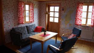 een woonkamer met een bank en een tafel en stoelen bij Norrvange Stugor in Kappelshamn