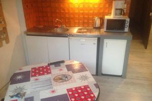 - une petite cuisine avec un comptoir et une table dans l'établissement Studio Belle Hutte 2, à La Bresse