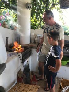 een man en een jongen die voor een grill staan bij B&B Al Salvatore Di Lipari in Lipari