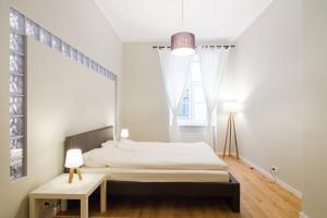 Dormitorio blanco con cama y mesa en Modern & Spacious 80m2 Apartment in Riga Old Town, en Riga