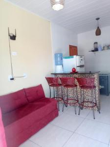 sala de estar con sofá rojo y cocina en Flat e Suítes Praia de São Bento, en Maragogi