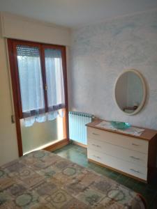 a bedroom with a bed and a mirror and a dresser at Caletta Beach in Castiglioncello