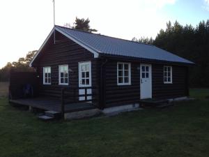 a small cabin with a porch and a roof at Norrvange Stugor in Kappelshamn