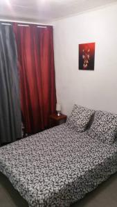 a bedroom with a bed and a red curtain at La Campagne in La Ciotat