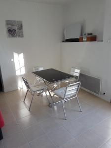 a table and chairs in a room with a tile floor at La Campagne in La Ciotat