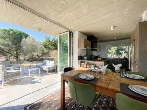 cocina y sala de estar con mesa de madera y sillas en Villa des Cathares, en Carcassonne