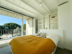 een slaapkamer met een bed en een groot raam bij Villa des Cathares in Carcassonne