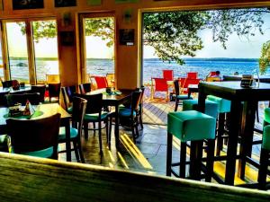 a restaurant with tables and chairs and a view of the water at Ferienwohnung Schwalbennest-Großkoschen in Großkoschen