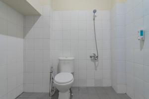 a white bathroom with a toilet and a shower at RedDoorz near Trans Studio Bandung 3 in Bandung