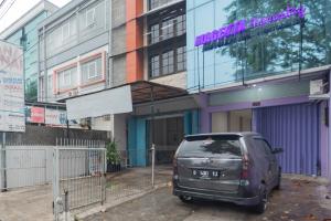 een kleine auto geparkeerd voor een gebouw bij RedDoorz near Trans Studio Bandung 3 in Bandung