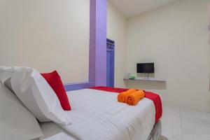 een slaapkamer met een bed met 2 oranje handdoeken erop bij RedDoorz near Trans Studio Bandung 3 in Bandung