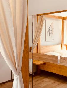 ein Schlafzimmer mit einem Spiegel und einem Bett in der Unterkunft Waldschlössl Schneedörfl in Reichenau