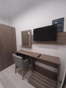 um quarto com uma secretária, uma televisão e uma cadeira em HARA BEACH em Rakhónion