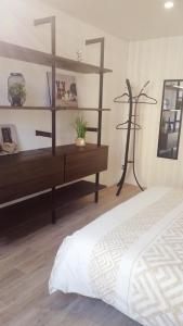 a bedroom with a bed and a wooden shelf at Le coryphée : Appartement en centre ville à Abbeville in Abbeville +4 photos