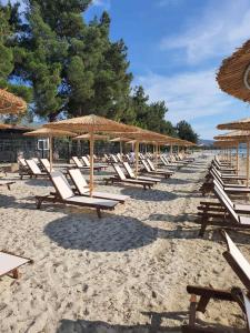 a row of lounge chairs and umbrellas on a beach at HARA BEACH in Rakhónion